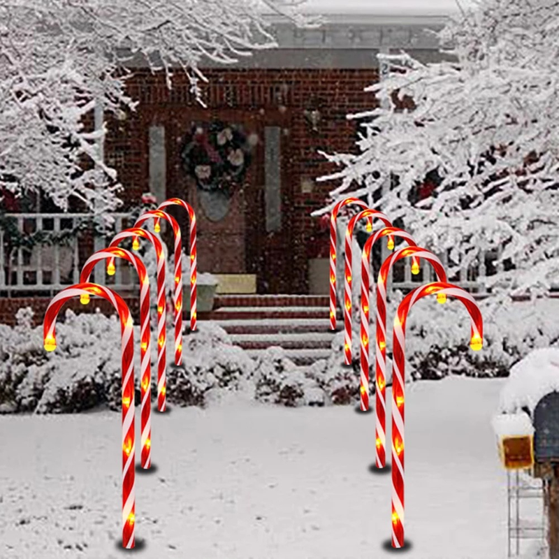 Candy cane path lights lining a snowy front walkway