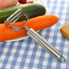 Stainless steel peeler on a carrot and cucumber