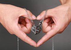 Hands making a heart shape around the split heart couple necklaces