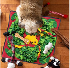 Dog sniffing for treats in the Christmas wreath snuffle mat