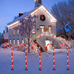 Candy cane path lights in front of a snowy house