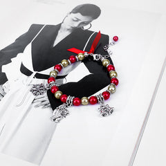 Christmas charm bracelet with Santa and bell charms shown on a magazine