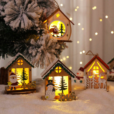 Glowing wooden Christmas houses on snow by a Christmas tree