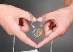Hands holding the silver and gold tone split heart couple necklaces